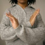 calm black woman crossed arms as restriction sign in light room