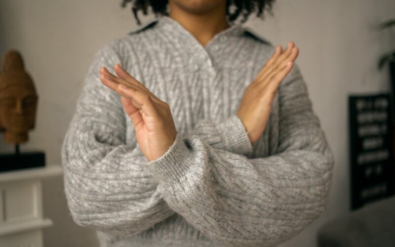 calm black woman crossed arms as restriction sign in light room