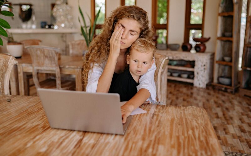 a mother using laptop with her son